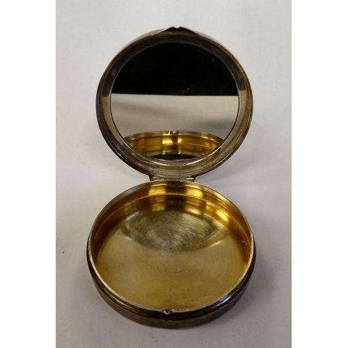 6 - A silver circular powder compact with a hinged, engine turned blue enamel lid and an applied emblem ... 