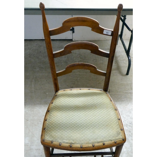 93 - A circa 1900 fruitwood framed, ladderback side chair with a stud upholstered seat pad, raised on tur... 