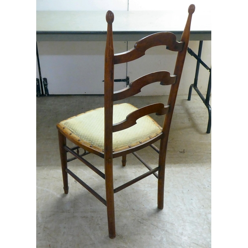 93 - A circa 1900 fruitwood framed, ladderback side chair with a stud upholstered seat pad, raised on tur... 