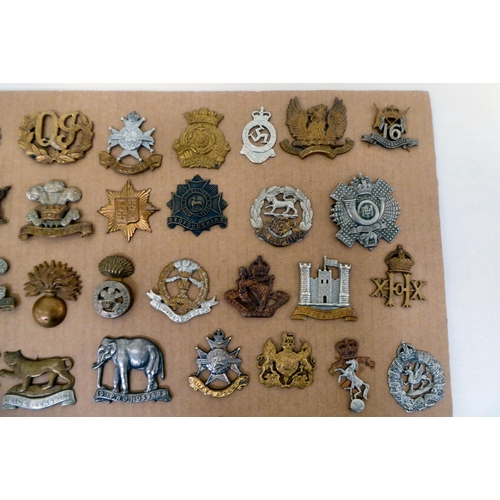 97 - Over fifty British military regimental cap badges and other insignia, some copies: to include Innisk... 