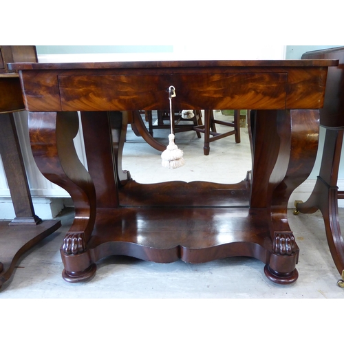 103 - A Regency style mahogany finished serving table, comprising a frieze drawer, elevated on S-shape for... 