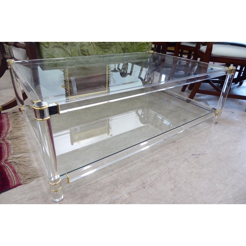 115 - In the manner of Ghost, a two tier coffee table, connected by cylindrical supports and bi-coloured c... 