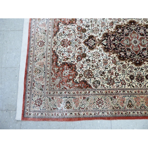 132 - A Persian part silk rug with dense floral decoration, on a beige and red ground  66