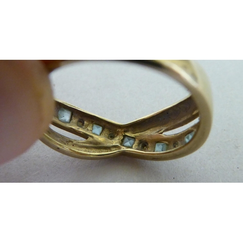 136 - A 9ct gold, diamond and blue topaz crossover ring