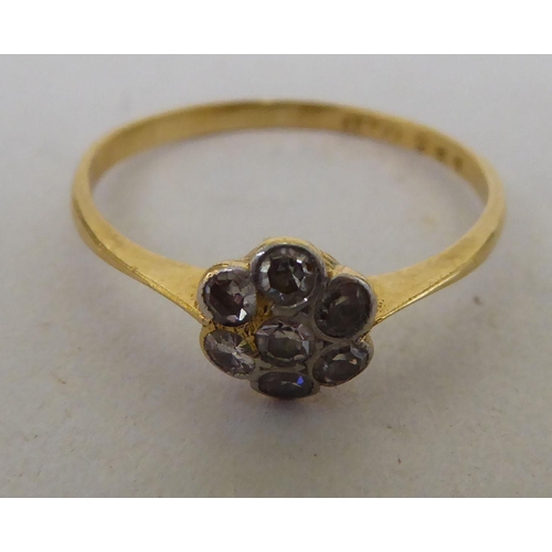 137 - An 18ct gold, diamond daisy design ring