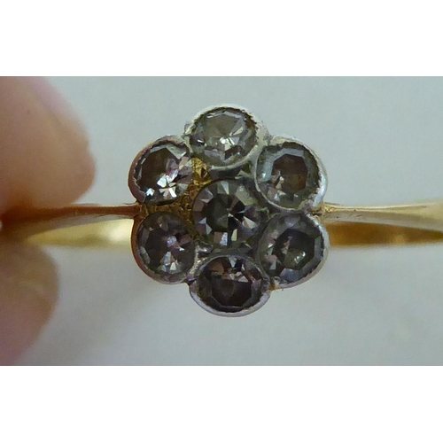 137 - An 18ct gold, diamond daisy design ring