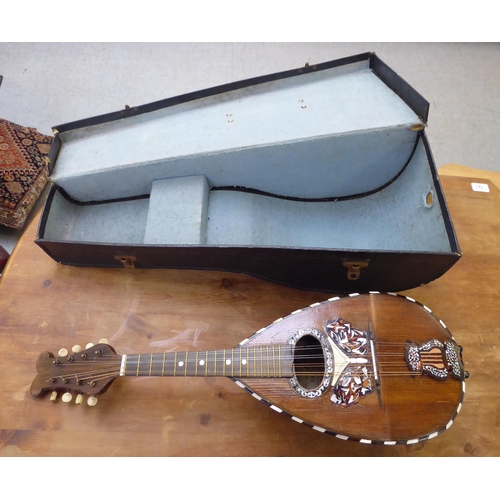 142 - A mandolin, the case with decoratively inlaid mother-of-pearl ornament, in a carrying case