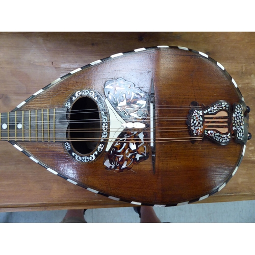 142 - A mandolin, the case with decoratively inlaid mother-of-pearl ornament, in a carrying case