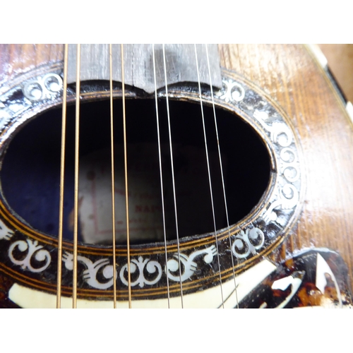 142 - A mandolin, the case with decoratively inlaid mother-of-pearl ornament, in a carrying case