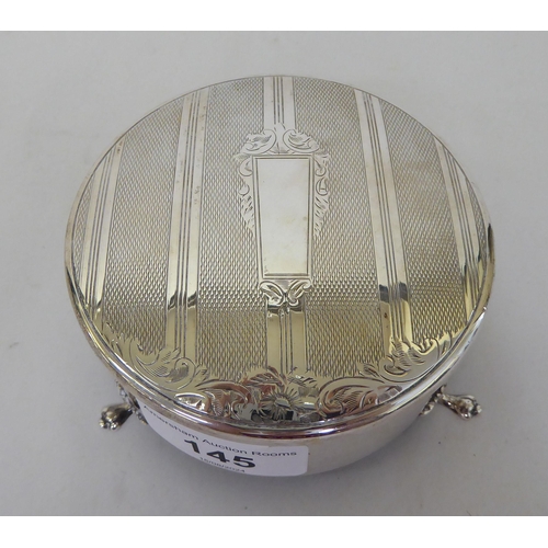 145 - A silver ring box of circular form with engraved and engine turned ornament on the hinged lid  ... 