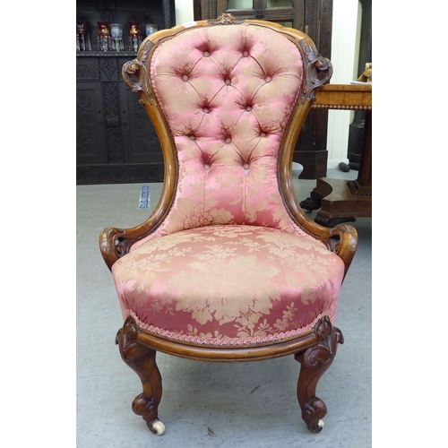 147 - A mid Victorian walnut framed nursing chair, later upholstered in floral patterned fabric, raised on... 