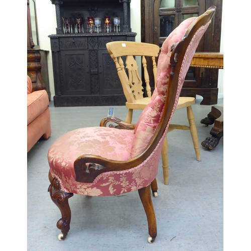 147 - A mid Victorian walnut framed nursing chair, later upholstered in floral patterned fabric, raised on... 