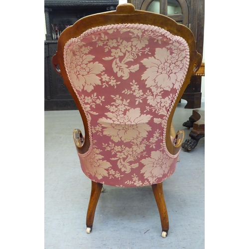 147 - A mid Victorian walnut framed nursing chair, later upholstered in floral patterned fabric, raised on... 