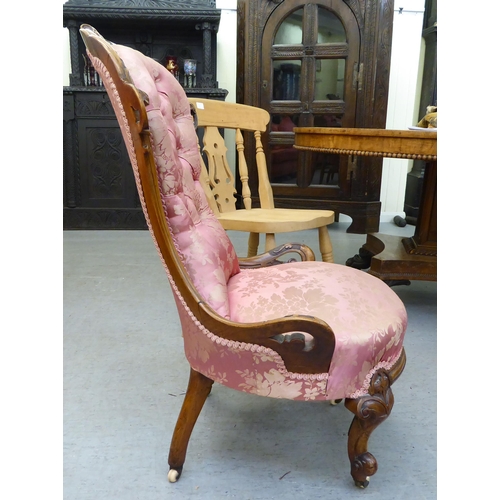 147 - A mid Victorian walnut framed nursing chair, later upholstered in floral patterned fabric, raised on... 