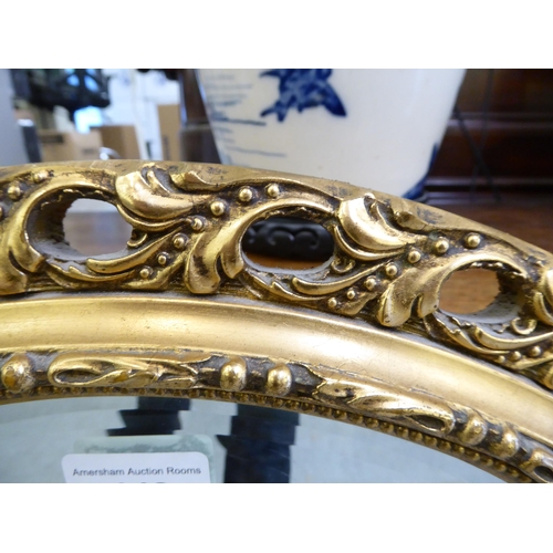 148 - A modern mirror, the arched bevelled plate set in a moulded gilt frame  34