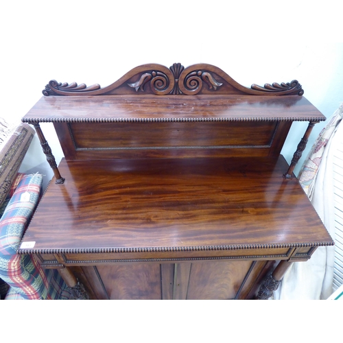 183 - A William IV mahogany chiffonier with a raised back, incorporating a shelf over a frieze drawer and ... 