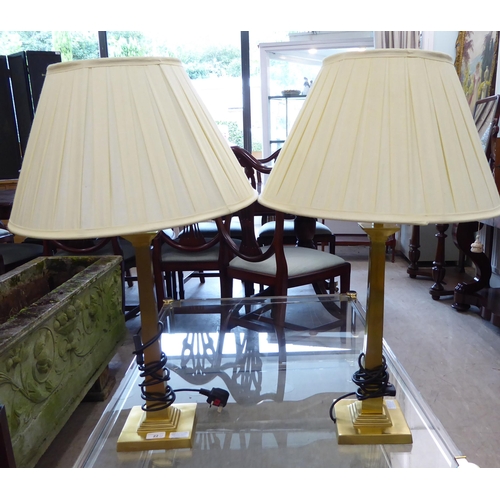 22 - A pair of gilt metal table lamps of pillar design  21