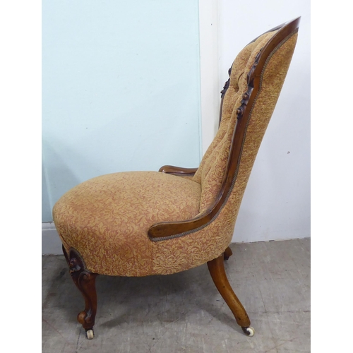 232 - A late Victorian walnut showwood framed nursing chair, part-button upholstered in floral patterned f... 