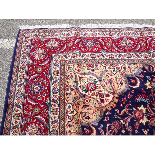 239 - An Iranian carpet, profusely decorated with floral and foliage designs, on a mainly dark blue and re... 