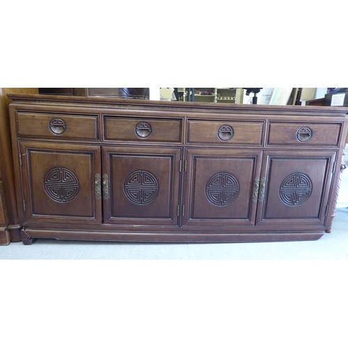 245 - A 20thC Chinese fruitwood dresser with four in-line drawers, over four panelled doors, raised on sha... 