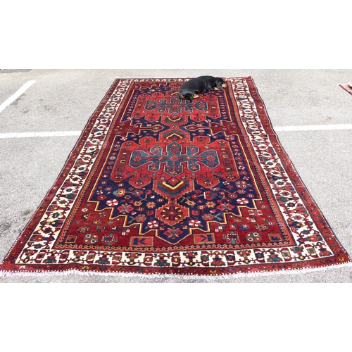 246 - A Persian carpet, decorated with mirrored decoration, on a multi-coloured ground  84