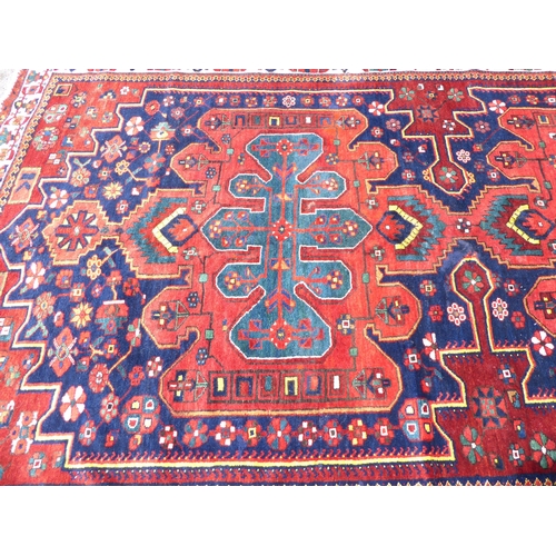 246 - A Persian carpet, decorated with mirrored decoration, on a multi-coloured ground  84