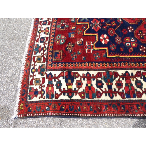 246 - A Persian carpet, decorated with mirrored decoration, on a multi-coloured ground  84