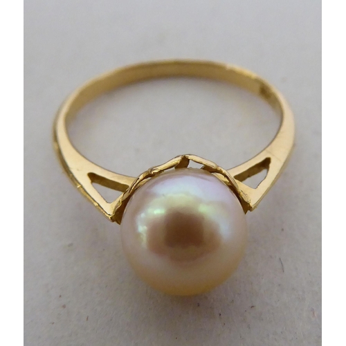 252 - Three yellow metal rings: to include one set with a pearl  stamped 18ct; and a three coloured s... 