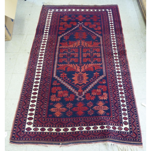 28 - A Persian rug, decorated with a central pole medallion, on a red ground  74