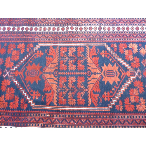 28 - A Persian rug, decorated with a central pole medallion, on a red ground  74