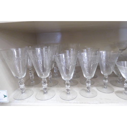 281 - A suite of glassware with foliage decorative banding: to include pedestal wines