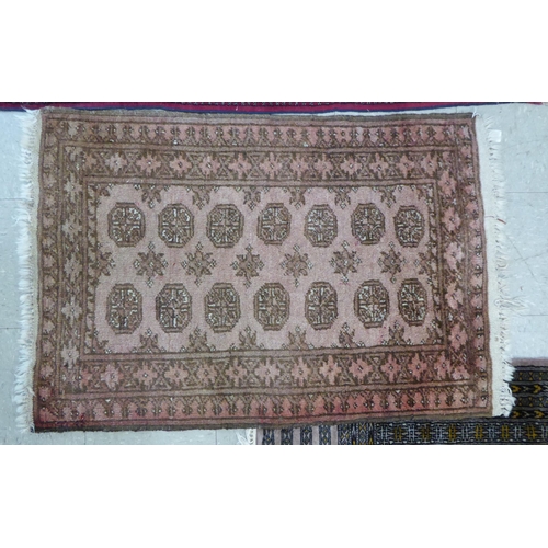 29 - Rugs: to include a Bokhara with elephant foot motifs, on a red ground  54