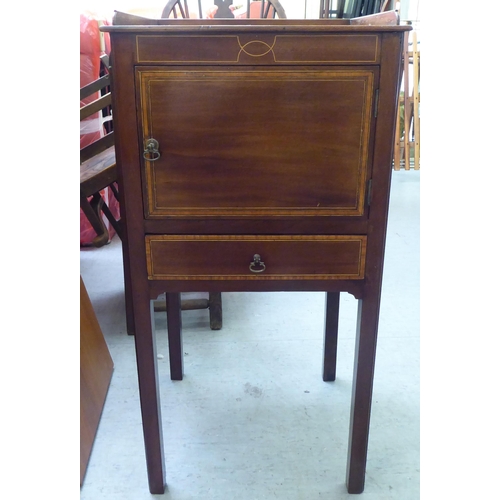 290 - An Edwardian mahogany pot cupboard with a low gallery, over a door and drawer, raised on square legs... 