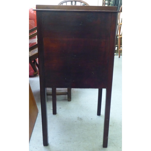 290 - An Edwardian mahogany pot cupboard with a low gallery, over a door and drawer, raised on square legs... 