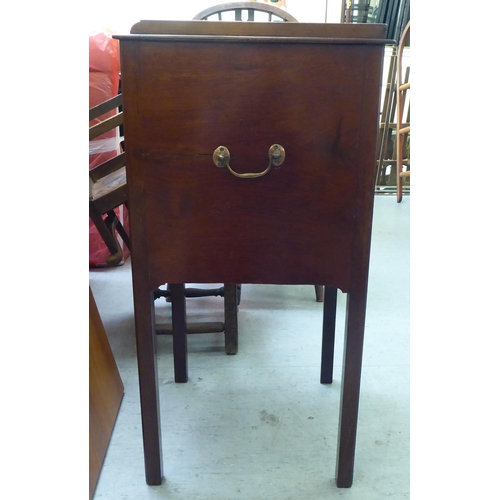 290 - An Edwardian mahogany pot cupboard with a low gallery, over a door and drawer, raised on square legs... 