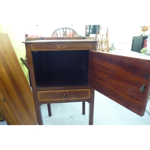 290 - An Edwardian mahogany pot cupboard with a low gallery, over a door and drawer, raised on square legs... 