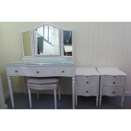 303 - A modern white painted serpentine front dressing table, surmounted by a triptych mirror, over three ... 