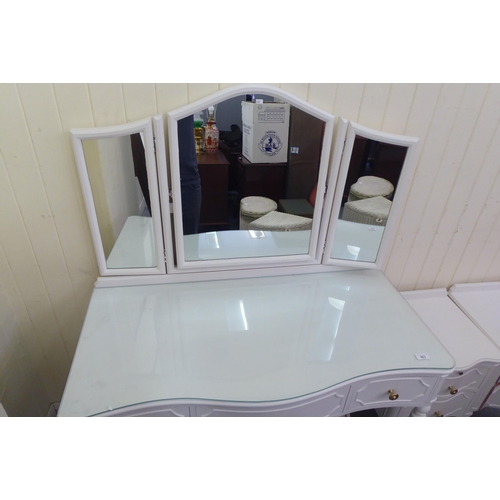 303 - A modern white painted serpentine front dressing table, surmounted by a triptych mirror, over three ... 