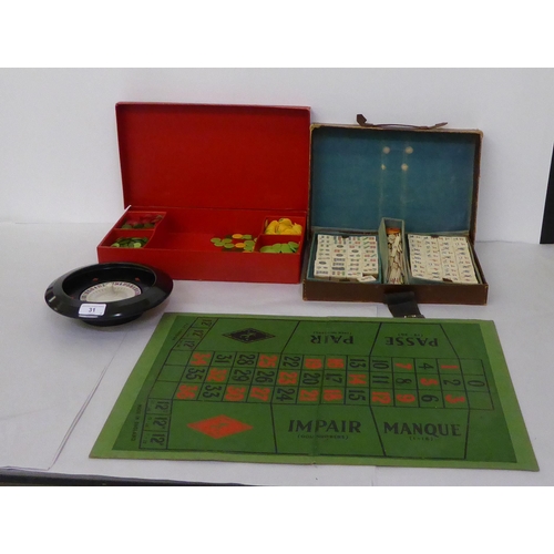 31 - Table games: to include a Mah Jong set, in a stitched brown hide case; and a Bakelite roulette wheel