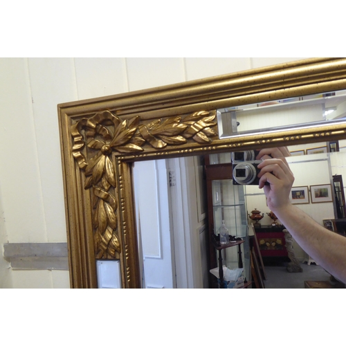 312 - A modern mirror with a multi-panelled, bevelled plate, in a gilt frame  74