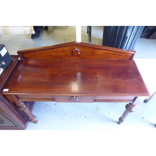 324 - A late Victorian mahogany serving side table with an arched upstand, over a central frieze drawer, r... 