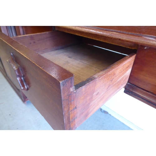 324 - A late Victorian mahogany serving side table with an arched upstand, over a central frieze drawer, r... 