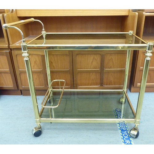 327 - A modern lacquered brass two tier tea trolley, on casters  30