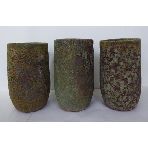 37 - A set of three naturalistically finished and randomly painted terracotta pots of tapered cylindrical... 