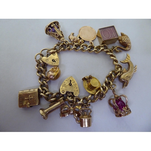 39 - A 9ct gold curb link charm bracelet, on a padlock clasp