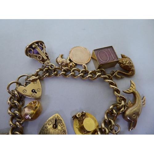 39 - A 9ct gold curb link charm bracelet, on a padlock clasp