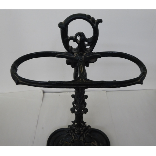 42 - An early 20thC green painted, cast iron stickstand, incorporating a drip tray, decorated in fruiting... 