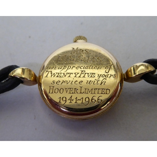 44 - A lady's Omega 9ct gold, round cased wristwatch, faced by a baton dial, on two strand hide strap&nbs... 