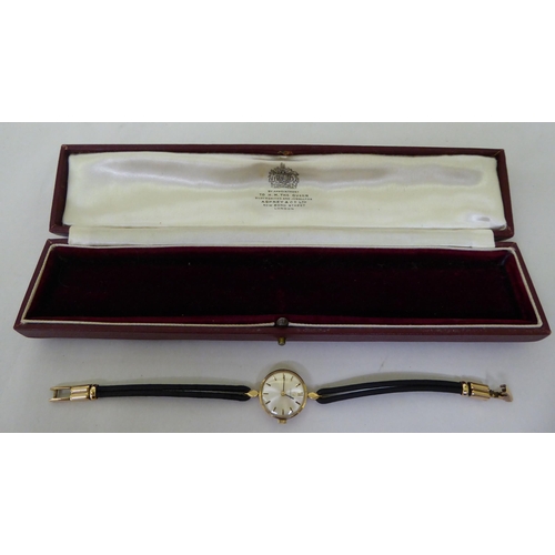 44 - A lady's Omega 9ct gold, round cased wristwatch, faced by a baton dial, on two strand hide strap&nbs... 