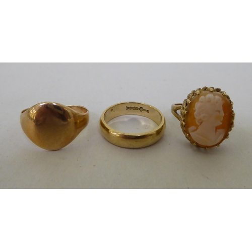 61 - Three 9ct gold rings, viz. a wedding band; a plain signet style example; and a claw set cameo